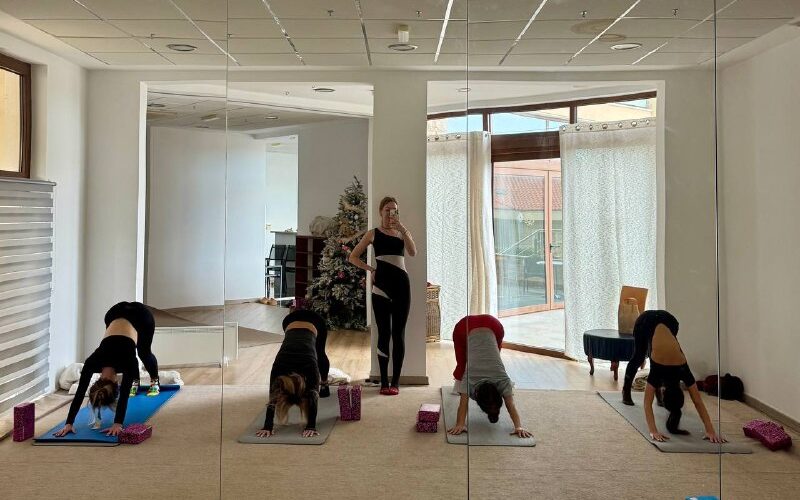 Участники йога-сессии в зале, отражайтесь в зеркале. Событие в Черногории, улучшение здоровья и гармонии.